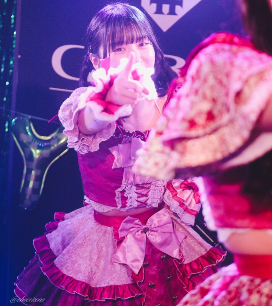 embellir(あんべりー)の水野ひなた(みずのひなた)ちゃんを最前列0番の位置からライブ中に撮影した写真。 ひなたちゃんはこの日の主役の七瀬ましろちゃんをリスペクトして先端をやや巻いたツインテールをしている。 ときめきフルスロットルの「君を見つけたの」の歌詞に合わせてこちらを見つめて指差してくれている。 2026年3月22日　神田CLUB F♯　七瀬ましろ生誕祭2026 ～ねぇねぇ教えて！ましろ、今日も可愛い？～にて撮影。