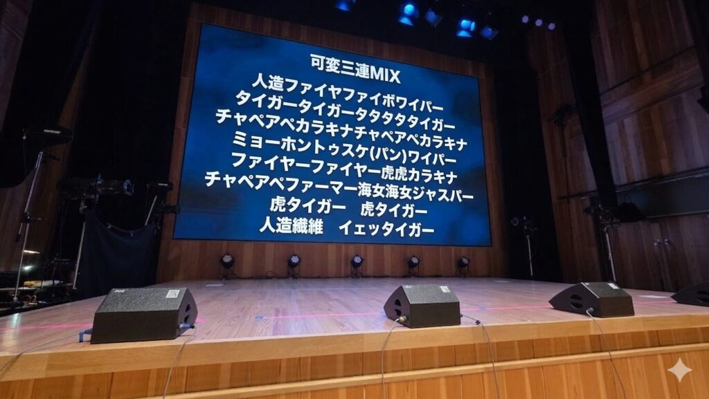 ステージのバックスクリーンにコールのテキストが映し出されている。以下コールの内容。 可変三連MIX 人造ファイヤファイボワイパー タイガータイガータタタタタイガー チャペアペカラキナチャペアペカラキナ ミョーホントゥスケ(パン)ワイパー ファイヤーファイヤー虎虎カラキナ チャペアペファーマー海女海女ジャスパー 虎タイガー　虎タイガー 人造繊維　イェッタイガー