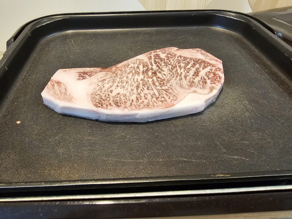 ホットプレートの上に乗ったステーキ。