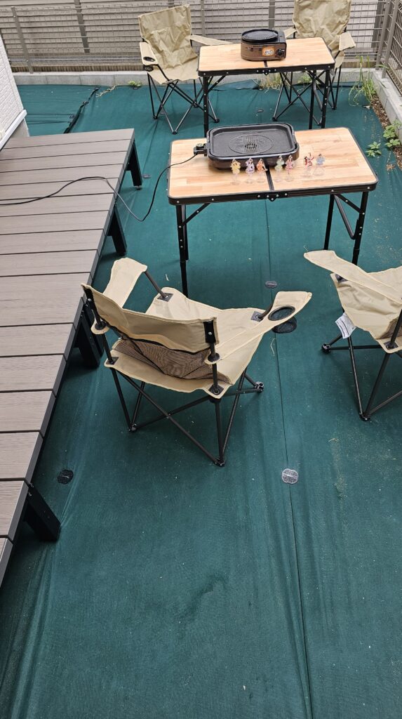 防草シートを張ってある庭でバーベキューをした時の様子。テーブルや椅子をを並べ、ホットプレートとガスコンロでバーベキューが出来るようになっている。