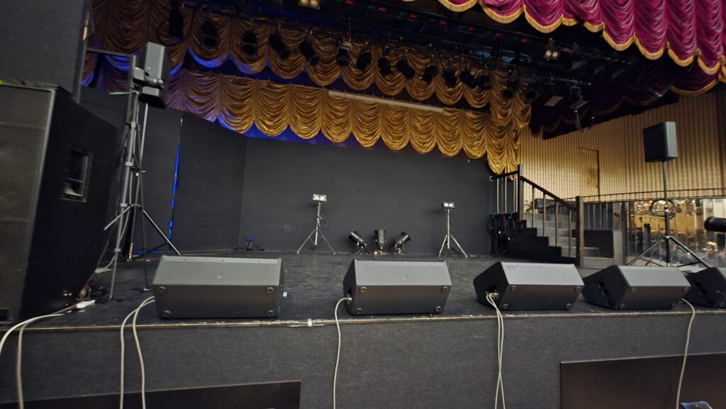 鶯谷新世紀ホールの下手2番あたりからステージの様子を撮影した写真。奥に階段で上がる小さな舞台もあり豪華な作りになっている。