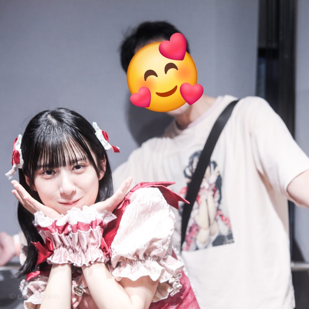 embellir(あんべりー)の水野ひなた(みずのひなた)ちゃんと特典会で撮ってもらったツーショット写真。 ひなたちゃんは毛先を外巻きにして赤いリボンを左右に着けている。 プレイフルの中である社交ダンス風のポーズを二人で再現。 2026年3月10日GOTANDA G4　無銭ぷろじぇくと!!にて撮影。