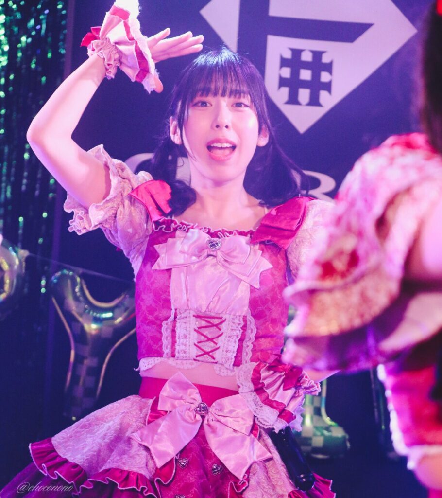 embellir(あんべりー)の水野ひなた(みずのひなた)ちゃんを最前列0番の位置からライブ中に撮影した写真。 ひなたちゃんはこの日の主役の七瀬ましろちゃんをリスペクトして先端をやや巻いたツインテールをしている。 ときめきフルスロットルの「君を見つけたの」の歌詞に合わせて手で頭の上にひさしを作って「見つけた！」のポーズ。 2026年3月22日　神田CLUB F♯　七瀬ましろ生誕祭2026 ～ねぇねぇ教えて！ましろ、今日も可愛い？～にて撮影。