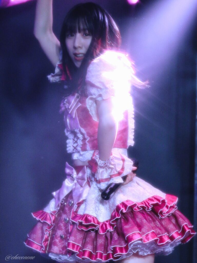 embellir(あんべりー)の水野ひなた(みずのひなた)ちゃんを最前列下手3番あたりからライブ中に撮影した写真。 ひなたちゃんはおろしたストレートヘアー。 ダンス中、照明が当たった肩のあたりが光を反射してキラキラしている。 ダンスの動きに合わせてふわっと浮いた髪に照明が当たってキラキラしている。 2026年3月27日GOTANDA G4 無銭ぷろじぇくと!!にて撮影。