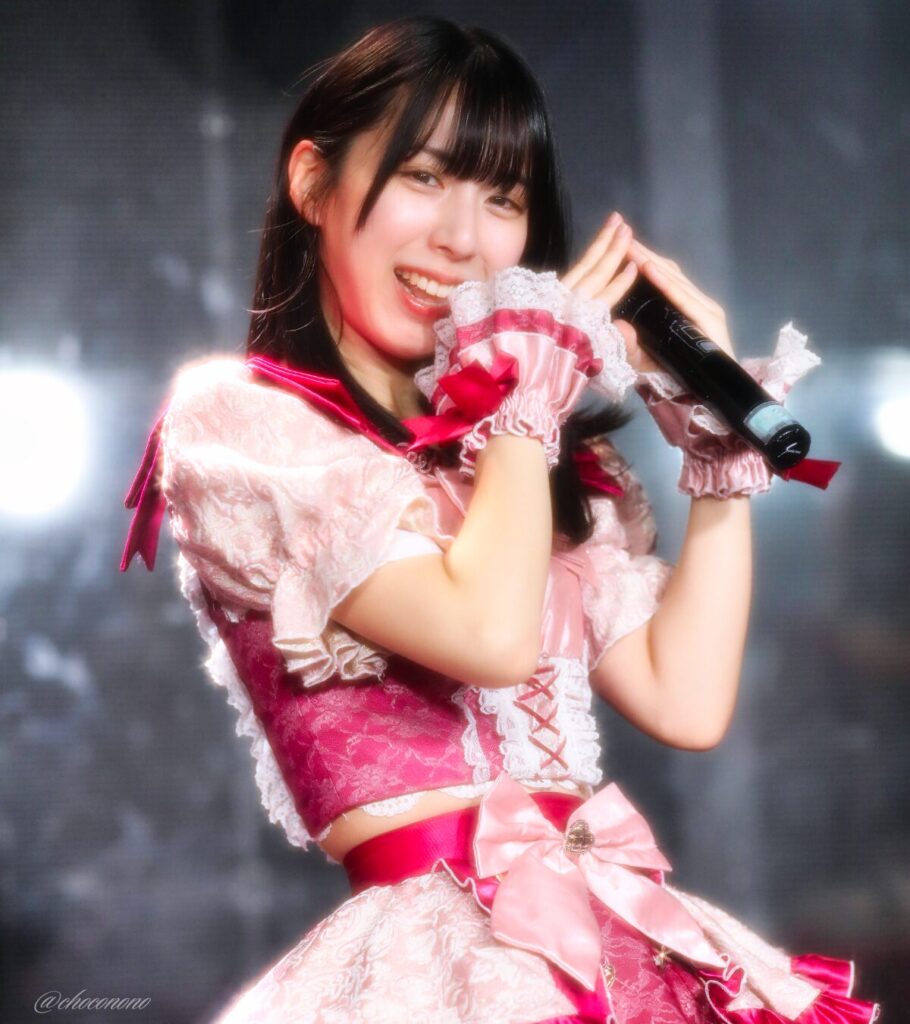 embellir(あんべりー)の水野ひなた(みずのひなた)ちゃんを最前列下手3番あたりからライブ中に撮影した写真。 ひなたちゃんはおろしたストレートヘアー。 手で「桃」を表すジェスチャーをしている。 2026年3月27日GOTANDA G4 無銭ぷろじぇくと!!にて撮影。