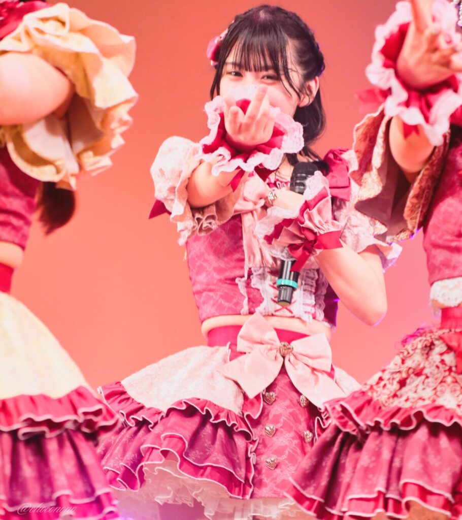 embellir(あんべりー)の水野ひなた(みずのひなた)ちゃんを最前列0番の位置からライブ中に撮影した写真。 ひなたちゃんは編み込みにくるみちゃんヘアー。衣装のイメージにぴったりなベリーカラーのリボンをしている。 ときめきフルスロットルの「君を求めてしまう」の歌詞に合わせてこちらに手を差し伸べてくれている。 2026年4月4日なかのZERO小ホール IDOL SODA Stream!!にて撮影。