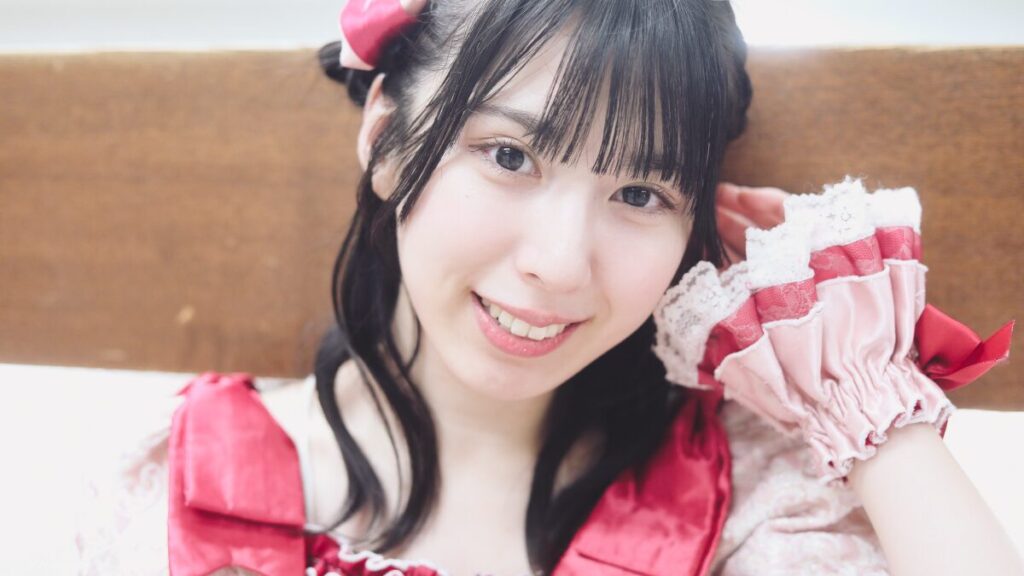 embellir(あんべりー)の水野ひなた(みずのひなた)ちゃんを特典会で撮らせてもらったソロショット写メ。 ひなたちゃんはくるみちゃんヘアーに衣装の色と同じピンクにベリー色のリボン。 髪にそっと触れる仕草がモデルのようにキマっている。 2026年4月4日なかのZERO小ホール IDOL SODA Stream!!にて撮影。