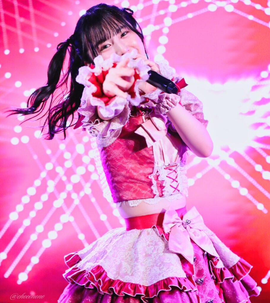 embellir(あんべりー)の水野ひなた(みずのひなた)ちゃんを最前列0番の位置からライブ中に撮影した写真。 ひなたちゃんはハーフツインの根元を輪っかに結んでハムちゃんヘアー。 こちらを見つめながらまっすぐ手を差し伸べてくれている。 2026年4月5日中野坂上S.U.B Tokyo 妃Fesにて撮影。