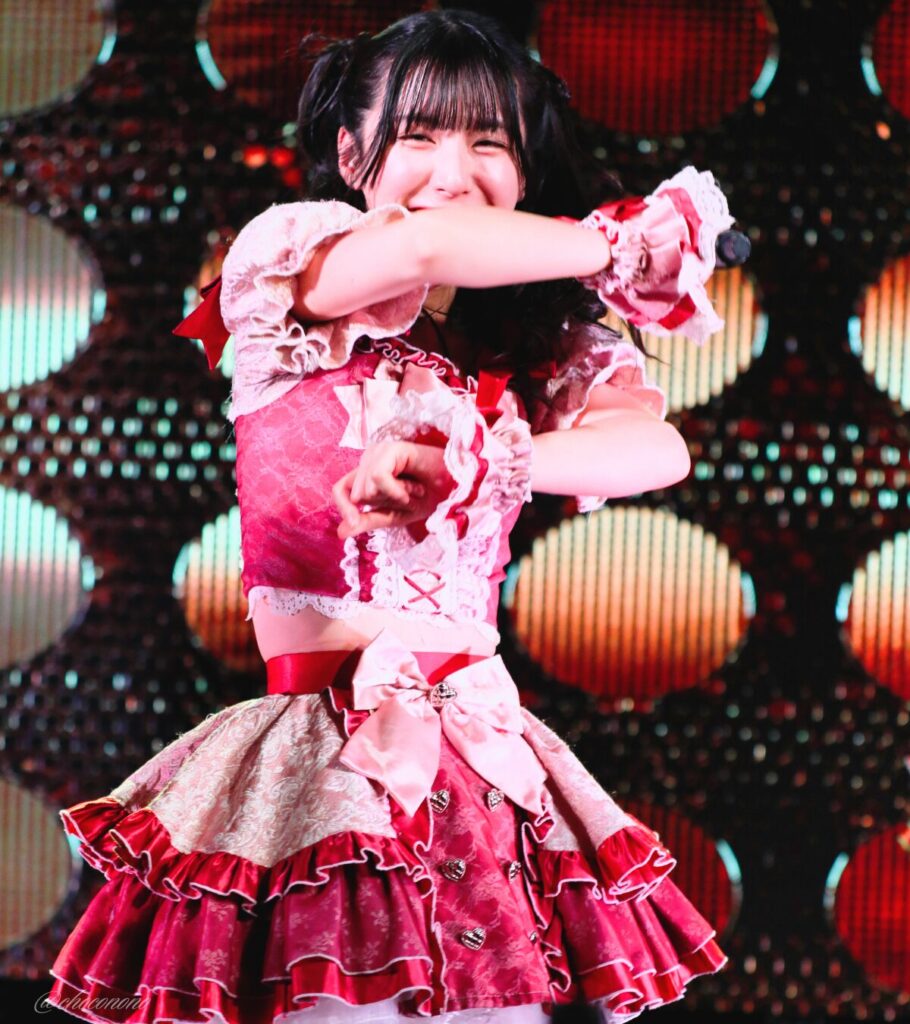 embellir(あんべりー)の水野ひなた(みずのひなた)ちゃんを最前列0番の位置からライブ中に撮影した写真。 ひなたちゃんはハーフツインの根元を輪っかに結んでハムちゃんヘアー。 ダンスの途中、右腕と左腕を平行に体の前に伸ばすポーズ。 2026年4月5日中野坂上S.U.B Tokyo 妃Fesにて撮影。