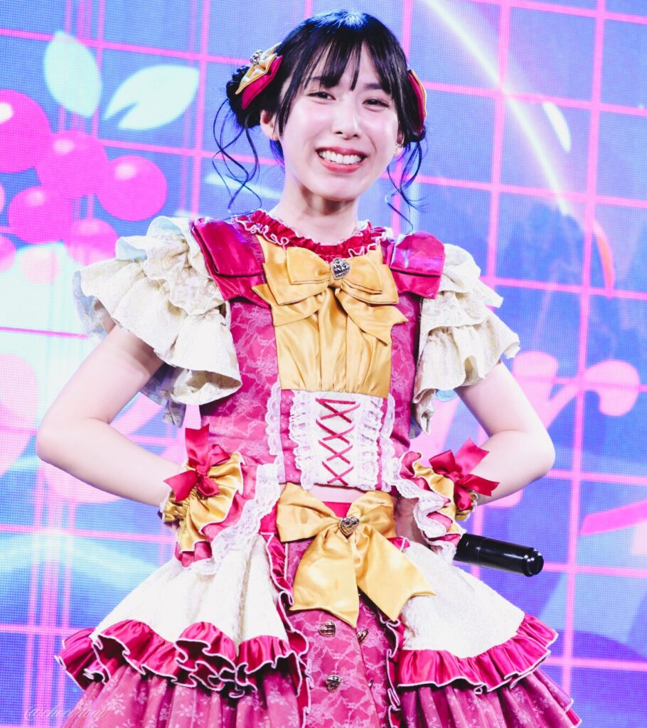 embellir(あんべりー)の水野ひなた(みずのひなた)ちゃんを最前列下手2番あたりからライブ中に撮影した写真 ひなたちゃんは普段と衣装を交換してきいろ色の衣装。お団子からちょろちょろとしっぽが出ているような髪型。 腰に手を当ててにこにこしながらこちらを見つめてくれている。 2026年4月9日SHIBUYA ONE5 embellir主催ライブにて撮影。