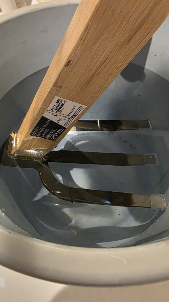 備中鍬の頭部を水に浸けているところ。