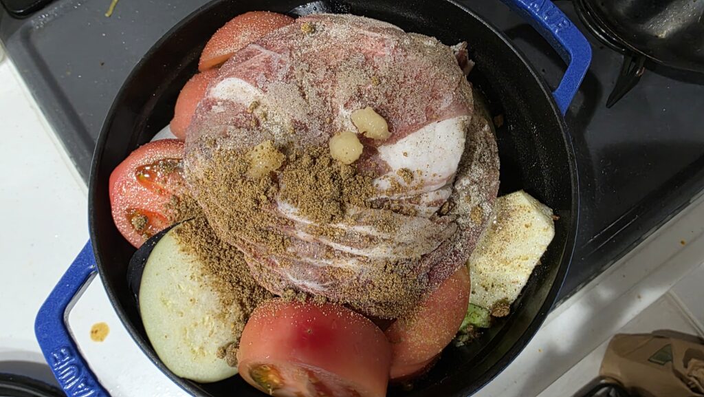 キャベツの嵩が減り、なす、ラム肉、トマト、塩こしょう、カレーパウダー、にんにくを追加した様子。