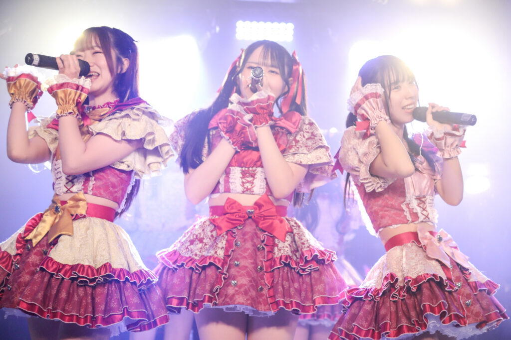 embellir(あんべりー)のライブ中の様子を撮影した写真。
左から泡沫(うたかた)あおいちゃん、遥乃(はるの)ももかちゃん、水野ひなたちゃんが横並びで歌唱している。