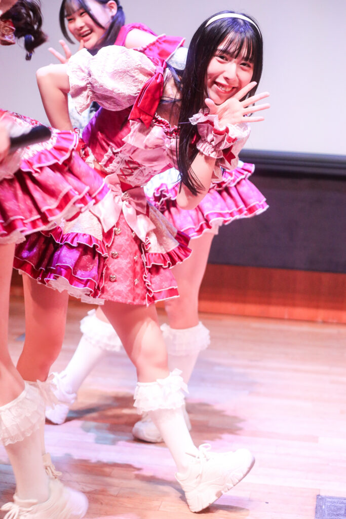 embellir(あんべりー)の水野ひなたちゃんをライブ中に撮影した写真。
カメラを向けているのに気づいて笑顔を向けてくれている。
2025年11月30日　渋谷SHIDAX Culture Hall　IDOL大博覧会にて撮影。