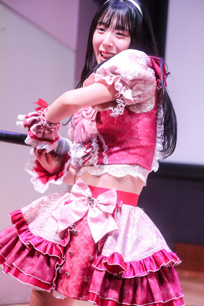 embellir(あんべりー)の水野ひなたちゃんをライブ中に撮影した写真。
腕を振り上げるポーズの途中。にこにこ笑顔が可愛い。
2025年11月30日　渋谷SHIDAX Culture Hall　IDOL大博覧会にて撮影。