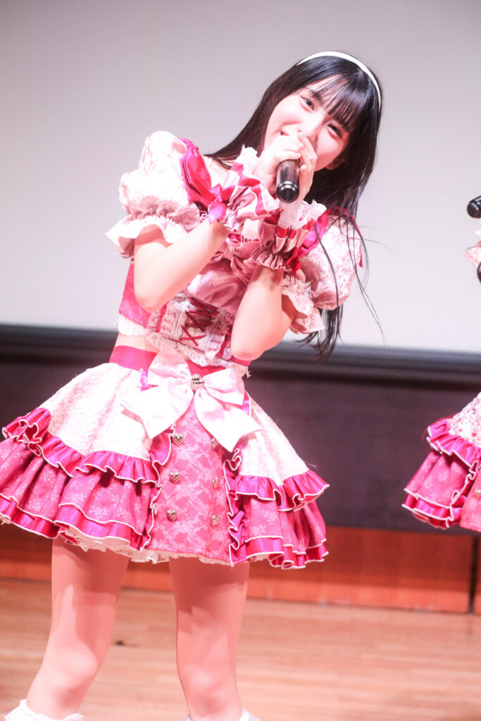 embellir(あんべりー)の水野ひなたちゃんをライブ中に撮影した写真。
MC中こちらをのぞき込むようにして笑いかけてくれている。可愛い。
2025年11月30日　渋谷SHIDAX Culture Hall　IDOL大博覧会にて撮影。