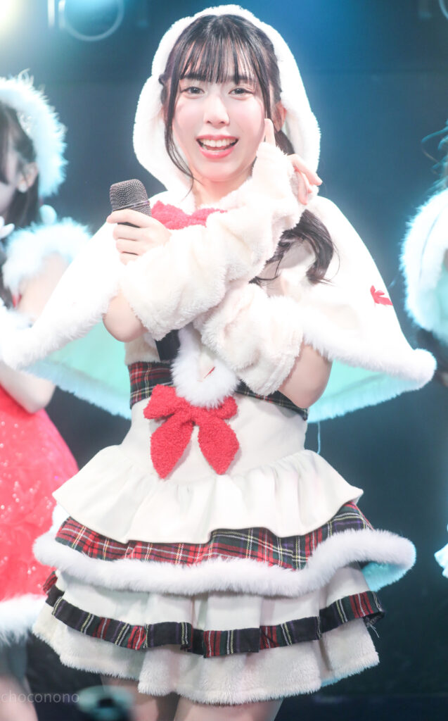 GOTANDA G3でembellir（あんべりー）の水野ひなた（みずのひなた）ちゃんをEOS 5D Mark IVとEF70-300mm（70mm）で縦位置に撮ったライブ写真。照明が正面から当たり、白い衣装で笑顔で小指を立てている。1/320、F4.0、ISO 1250。