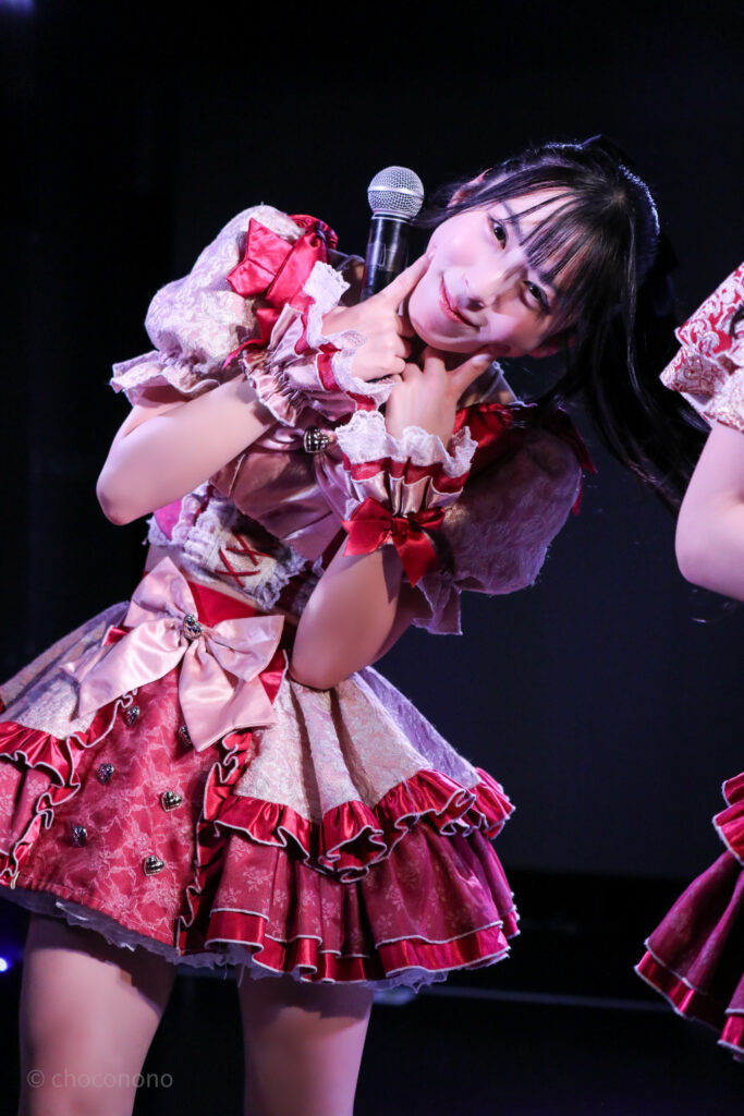 embellir(あんべりー)の水野ひなた(みずのひなた)ちゃんを最前0番からライブ中に撮影した写真。 お気に入りの紺色のリボンにポニーテール。 こちらをまっすぐに見つめながらほっぺたに指を当ててにこっと笑いかけてくれている。 2026年1月18日中野坂上S.U.B Tokyo IDOL ADVENTUREにて撮影