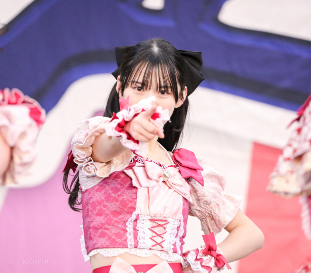 embellir(あんべりー)の水野ひなた(みずのひなた)ちゃんを三列目真ん中あたりからライブ中に撮影した写真。黒い大きなリボンが見えている。ときめきフルスロットルの「君を見つけたの」の歌詞に合わせてこちらを真っ直ぐ見つめながら指さしてくれている。 2026年1月25日上野水上音楽堂 超FREE BOMBER!!にて撮影