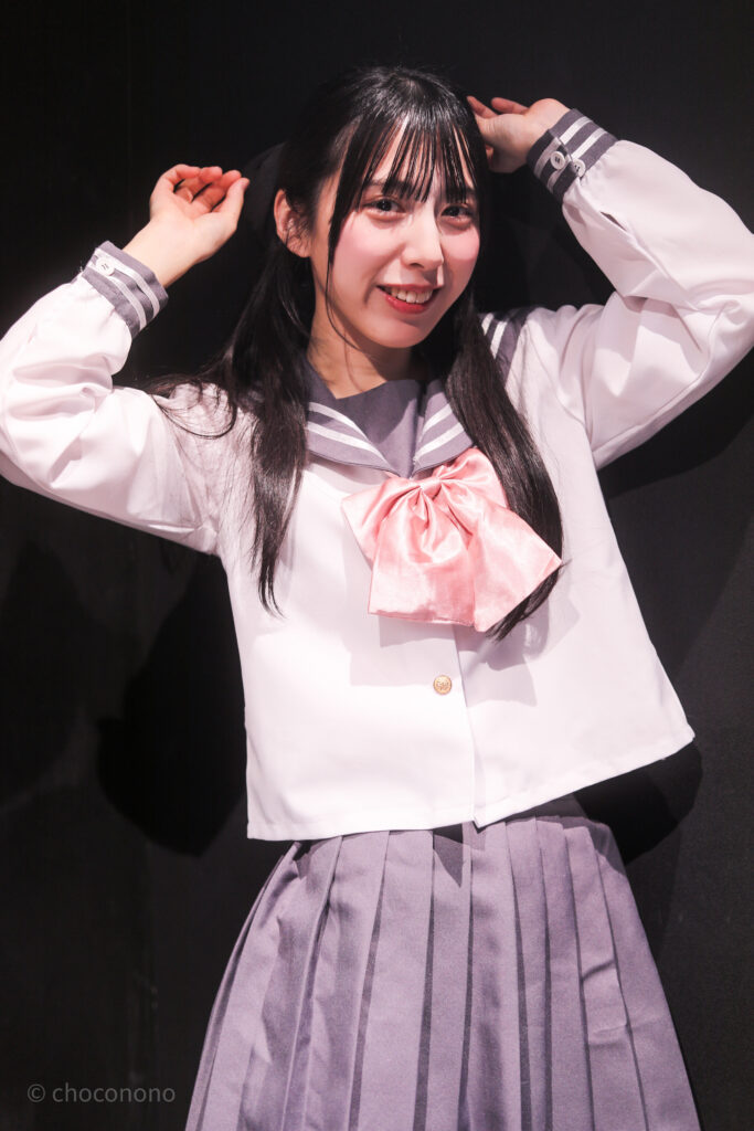 embellir(あんべりー)の水野ひなた(みずのひなた)ちゃんを特典会で撮らせてもらったソロショット写真。ひなたちゃんはピンクリボンの可愛いセーラー服。頭のリボンが写るように強調してくれている。 2026年2月14日新宿DHNoA　IDOL FABRIC Valentineにて撮影。