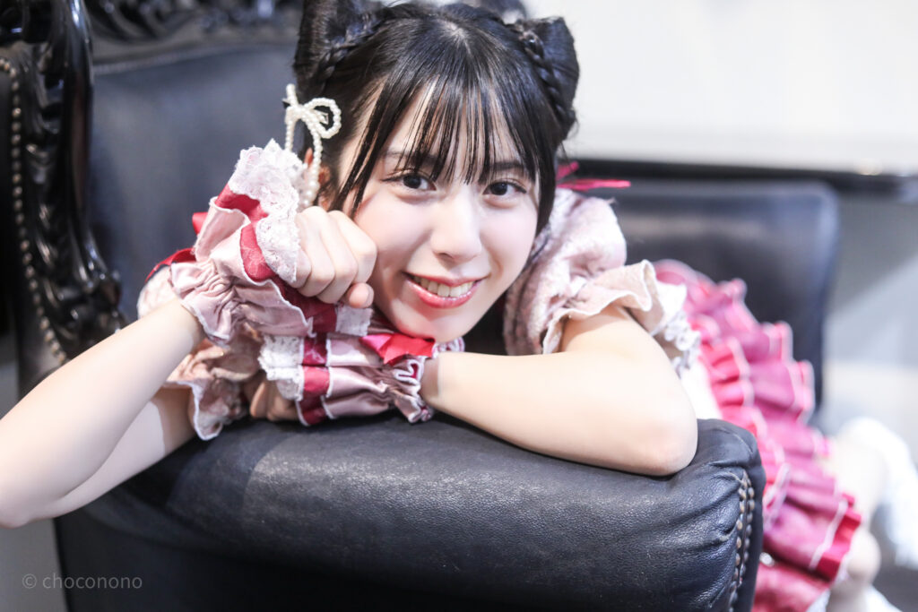 embellir(あんべりー)の水野ひなた(みずのひなた)ちゃんを特典会で撮らせてもらったソロショット写真。 ひなたちゃんは髪で猫耳を作っている。 ソファーから身を乗り出して猫のポーズをしてくれている。 2026年2月22日中野坂上S.U.B Tokyo　妃Fesにて撮影。