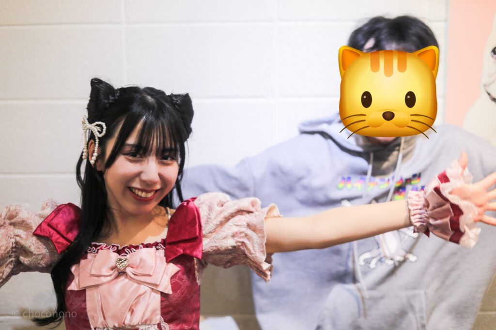 embellir(あんべりー)の水野ひなた(みずのひなた)ちゃんと特典会で撮ってもらったツーショット写真。 ひなたちゃんは髪で猫耳を作っている。 私のパーカーのプリントの「ハイテンションタイム」を再現して手足をバタバタさせたが、ひなたちゃんが私を守ろうとしてくれているようなポーズで止まっていた。 2026年2月22日中野坂上S.U.B Tokyo　妃Fesにて撮影。