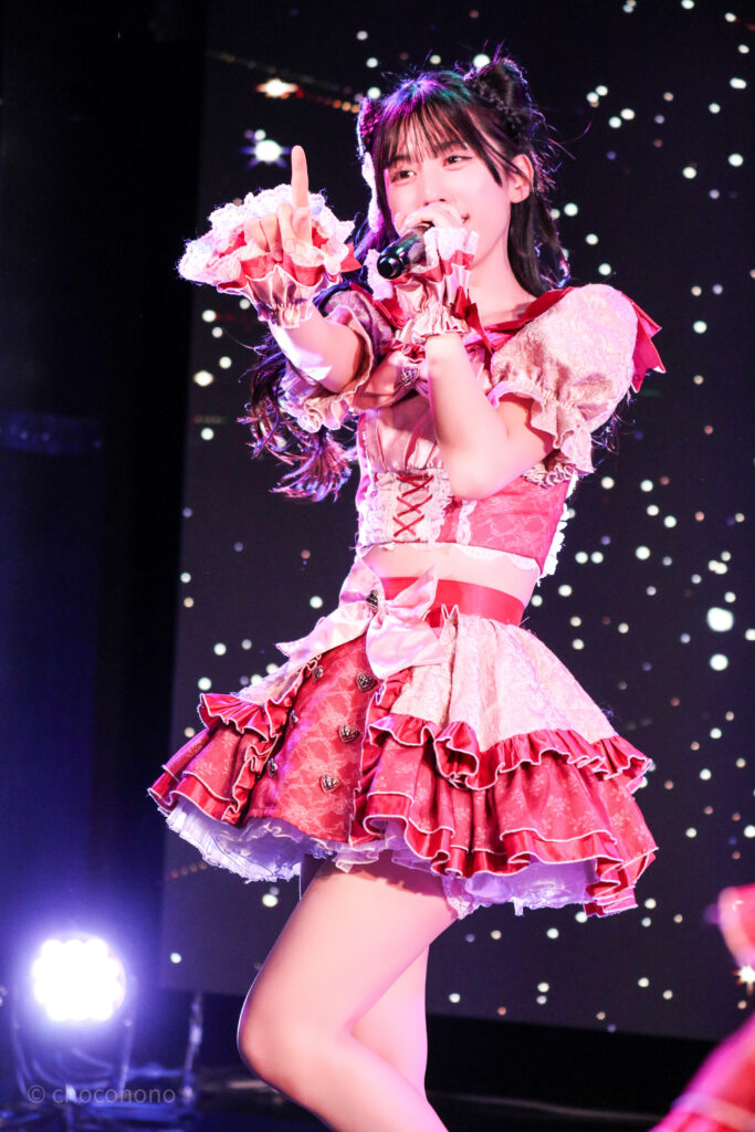 embellir(あんべりー)の水野ひなた(みずのひなた)ちゃんを最前列0番の位置から撮影したライブ写真。 ひなたちゃんは髪で猫耳を作っている。 前に向かって人差し指をピンと立てながら歌唱している。 2026年2月22日中野坂上S.U.B Tokyo　妃Fesにて撮影。