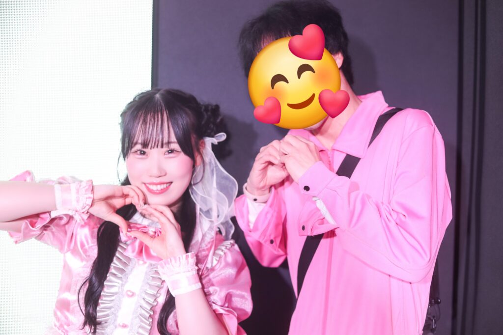 embellir(あんべりー)の甘夏あも(あまなつあも)ちゃんと特典会で撮ってもらったツーショット写真。 あもちゃんはひつじさんヘアーに白のリボン、派手めのピンク衣装を着ている。二人でハートを作っている。 2026年3月3日SHIBUYA ONE5　embellir presentsひなまつりにて撮影。