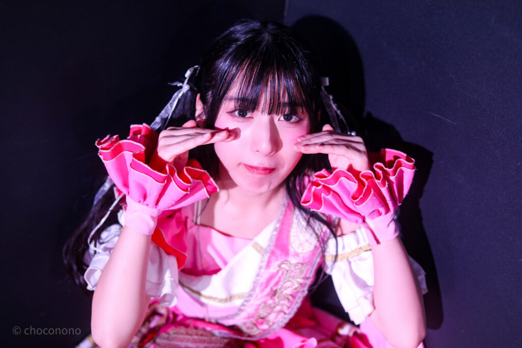 embellir(あんべりー)の水野ひなた(みずのひなた)ちゃんを特典会で撮らせてもらったソロショット写真。 ひなたちゃんはツインテールに白のリボン、姉妹グループ瞬きもせずの襷衣装のピンクを着ている。今は卒業してしまった元推しメン、琴音ゆあちゃんが当時着ていたもの。 ﾐｰと言いながら嘘泣きしている。 2026年3月3日SHIBUYA ONE5　embellir presentsひなまつりにて撮影。