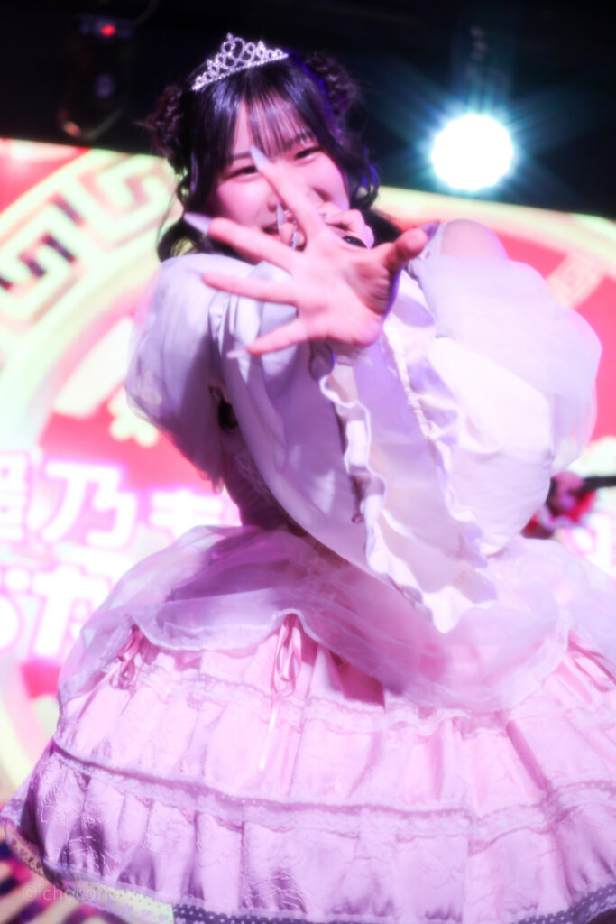 embellir(あんべりー)の恋羽あゆう(こはねあゆう)ちゃんを最前列下手2番あたりから撮ったライブ写真。 生誕衣装のピンクのドレスを着て、ティアラを着けている。羊さんヘアー。 こちらに手をさしのべてくれている。 2026年3月14日SHIBUYA ONE5　遥乃ももか×恋羽あゆうおたんじょうびかいにて撮影