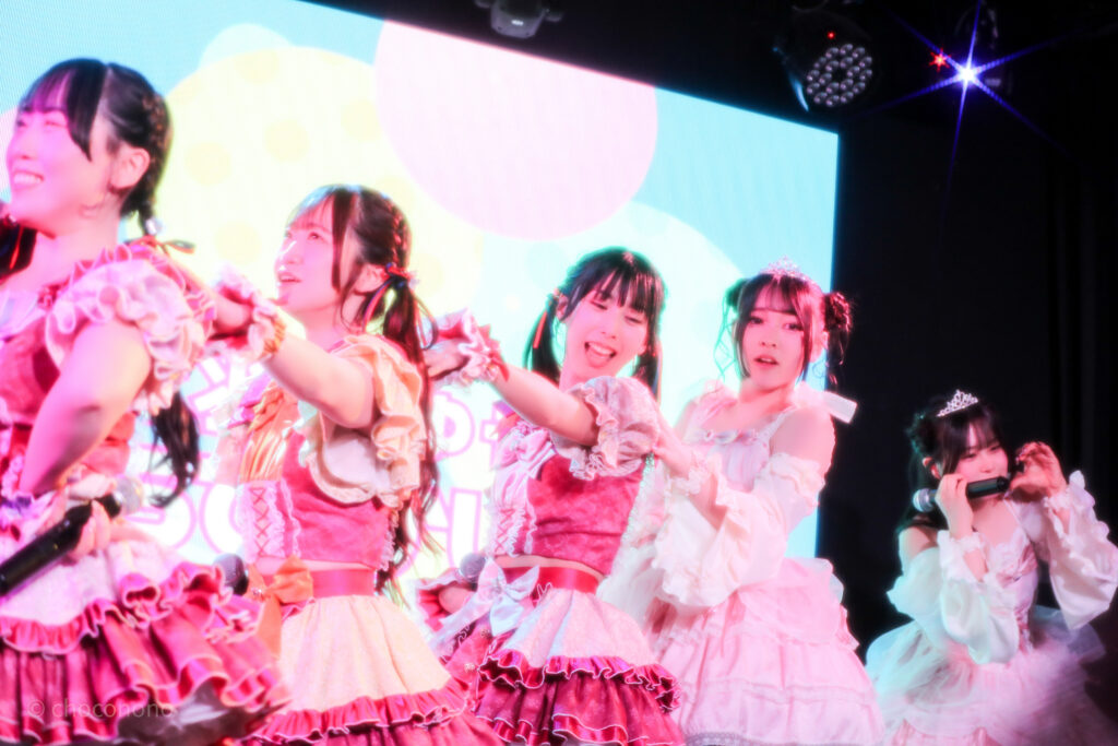 embellir(あんべりー)を最前列下手2番あたりから撮ったライブ写真。 左から甘夏あも(あまなつあも)ちゃん、泡沫あおい(うたかたあおい)ちゃん、水野ひなた(みずのひなた)ちゃん、遥乃ももか(はるのももか)ちゃん、恋羽あゆう(こはねあゆうちゃん)。プレイフルの間奏、前のメンバーの肩に手を置いて電車ごっこのようにしている。 2026年3月14日SHIBUYA ONE5　遥乃ももか×恋羽あゆうおたんじょうびかいにて撮影