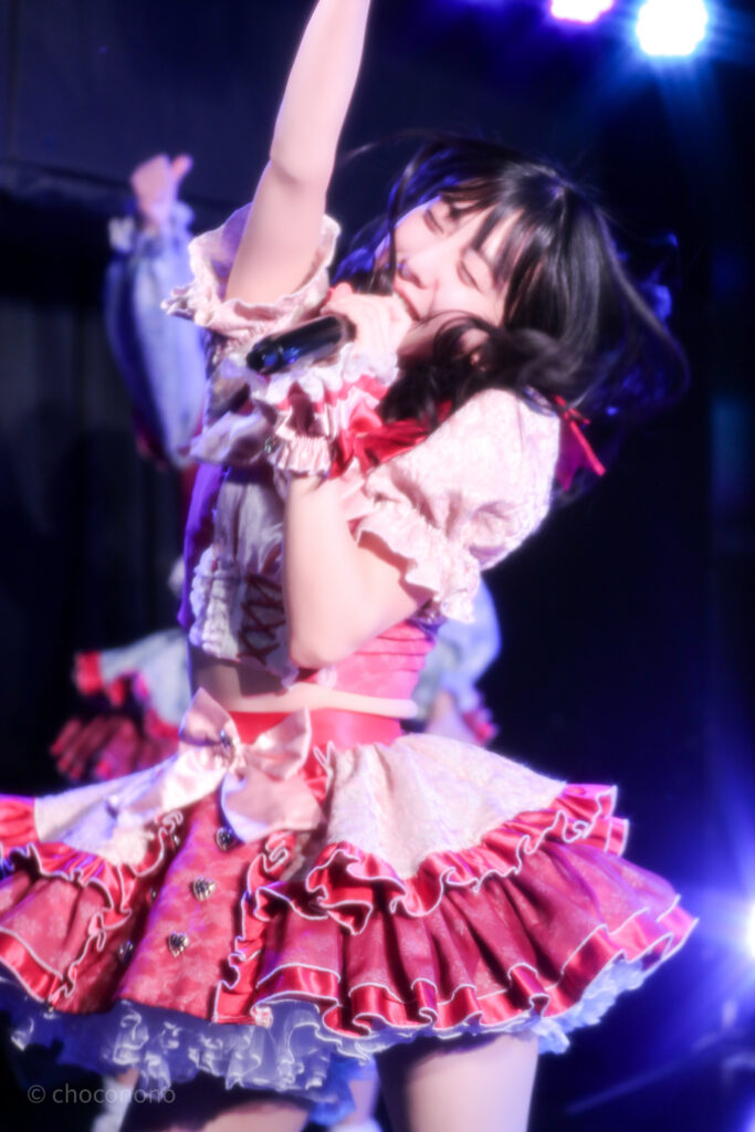 embellir(あんべりー)の水野ひなた(みずのひなた)ちゃんを最前列0番の位置からライブ中に撮影した写真。 ひなたちゃんはストレートヘアーをベースに一束髪を編んでいる。 笑顔で踊っていて髪の毛がダイナミックに動いている。 2026年3月15日中野坂上S.U.B Tokyo　妃Fesにて撮影。