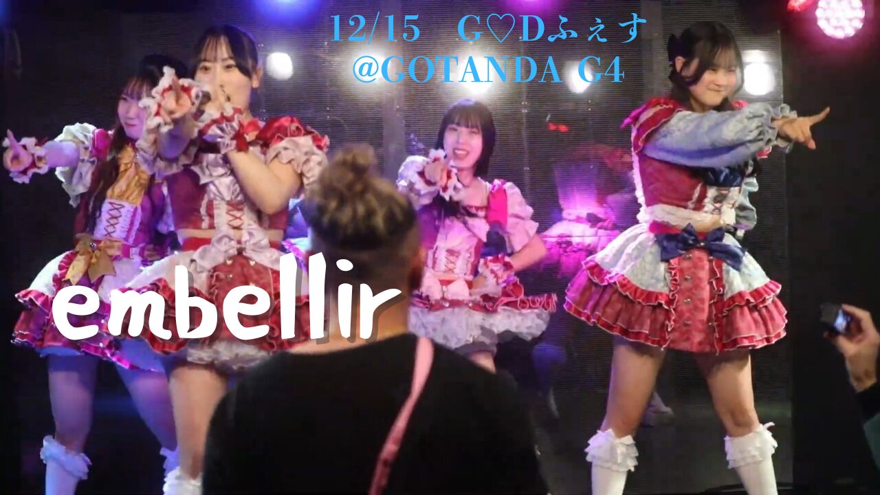 embellirメンバーが横並びになってそれぞれフロアの一点を指さしているシーンのスクリーンショット。グループ名とイベント詳細のテキストを埋め込んでいる。