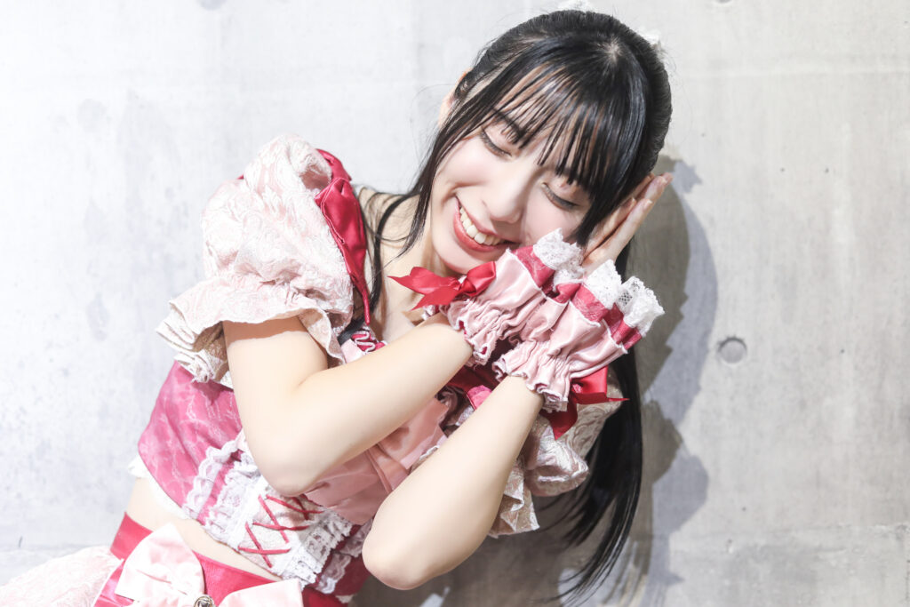 embellir(あんべりー)の水野ひなたちゃんを特典会で撮影したソロショット。
すやすやと寝ているようなポーズ。
だけどとても楽しそうににこにこしているので嘘寝なのがすぐ分かってしまう。
2025年12月4日　渋谷VIDENT　ライブジムにて撮影。