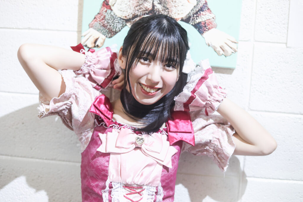 embellir(あんべりー)の水野ひなたちゃんを特典会で撮影したソロショット。
ポニーテールをマフラーの代わりに巻いてにこにこ微笑んでいる。可愛い。
2025年12月6日　中野坂上S.U.B Tokyo　IDOL GARDEN PLACEにて撮影