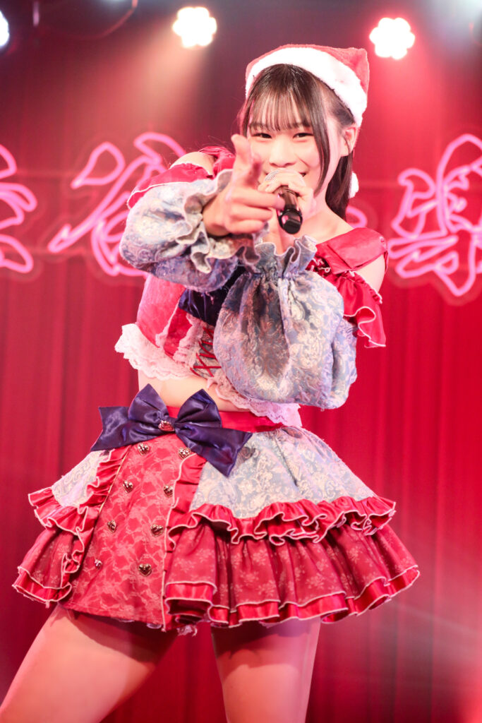 embellir(あんべりー)の恋羽あゆうちゃんをライブ中に撮影した写真。
真っ直ぐにこちらを指さして笑顔を向けてくれている。
2025年12月13日　渋谷音楽堂　ワンミリにて撮影。