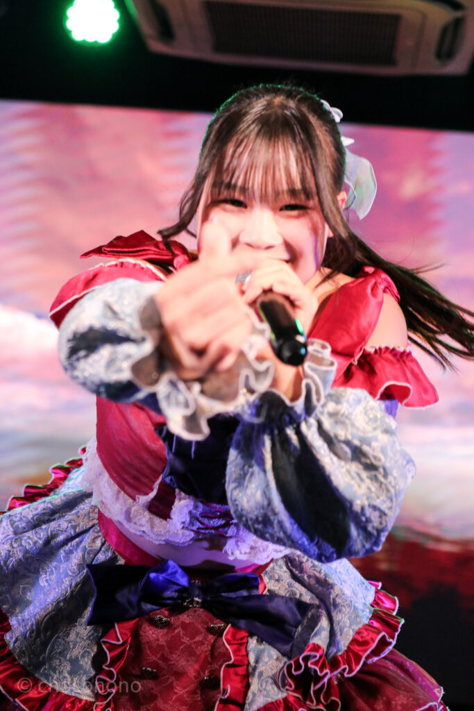 embellir(あんべりー)の恋羽あゆう(こはねあゆう)ちゃんをライブ中に撮影した写真。
こちらに向けて笑顔で指ハートを送ってくれている。
2025年12月21日 中野坂上S.U.B Tokyo IDOL ADVENTUREにて撮影。