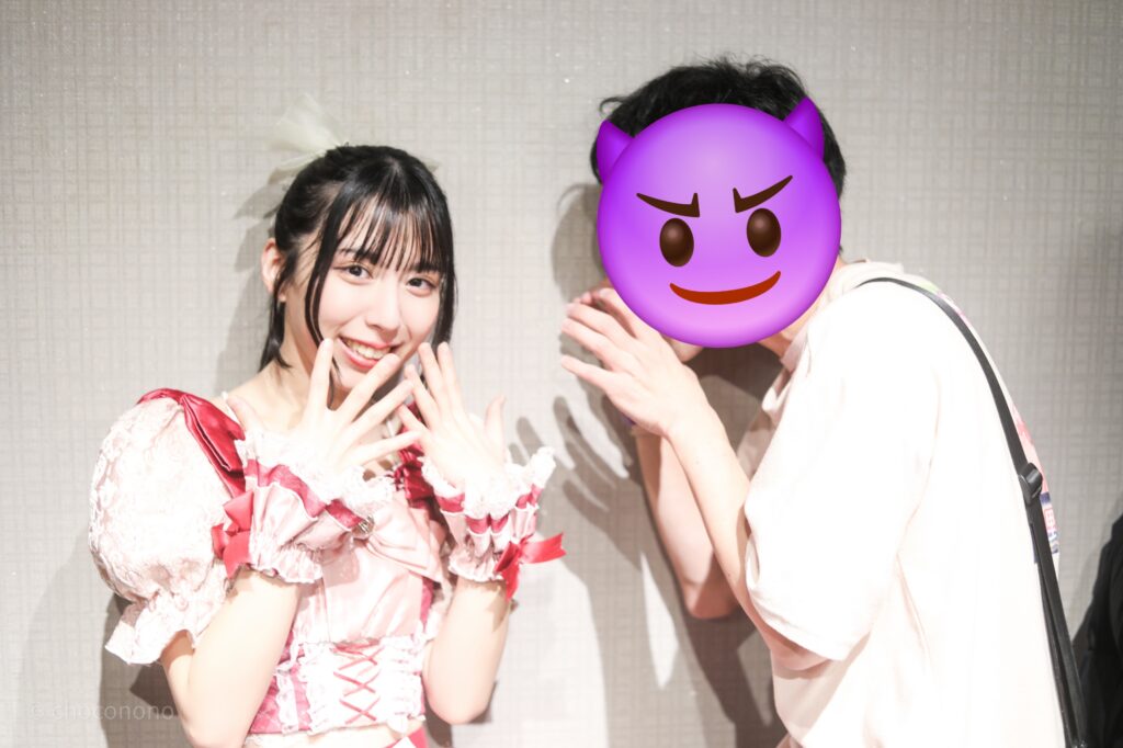 embellir(あんべりー)の水野ひなた(みずのひなた)ちゃんと特典会で撮ってもらったツーショット写真。
血を吸うために噛みつこうとしている私の様子に「きゃー！」と口元を手で覆っている。可愛い。
2025年12月30日GOTANDA G3　FREE BOMBERにて撮影。