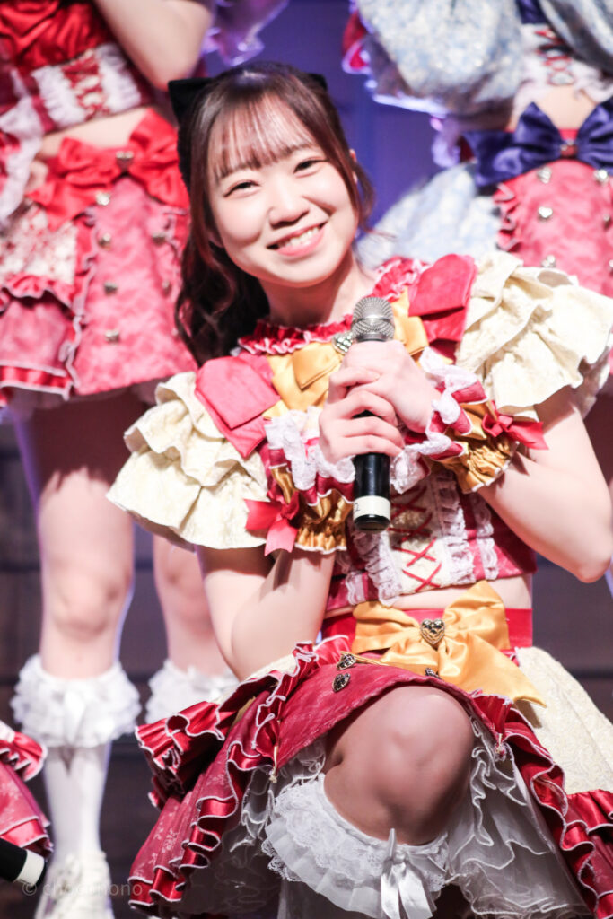 embellir(あんべりー)の泡沫あおい(うたかたあおい)ちゃんをライブ中に撮影した写真。
あおいちゃんがしゃがんで目線の高さがあったのでにっこりと微笑んでくれている。
2025年12月29日時事通信ホール　ヴェルサウンドにて撮影。