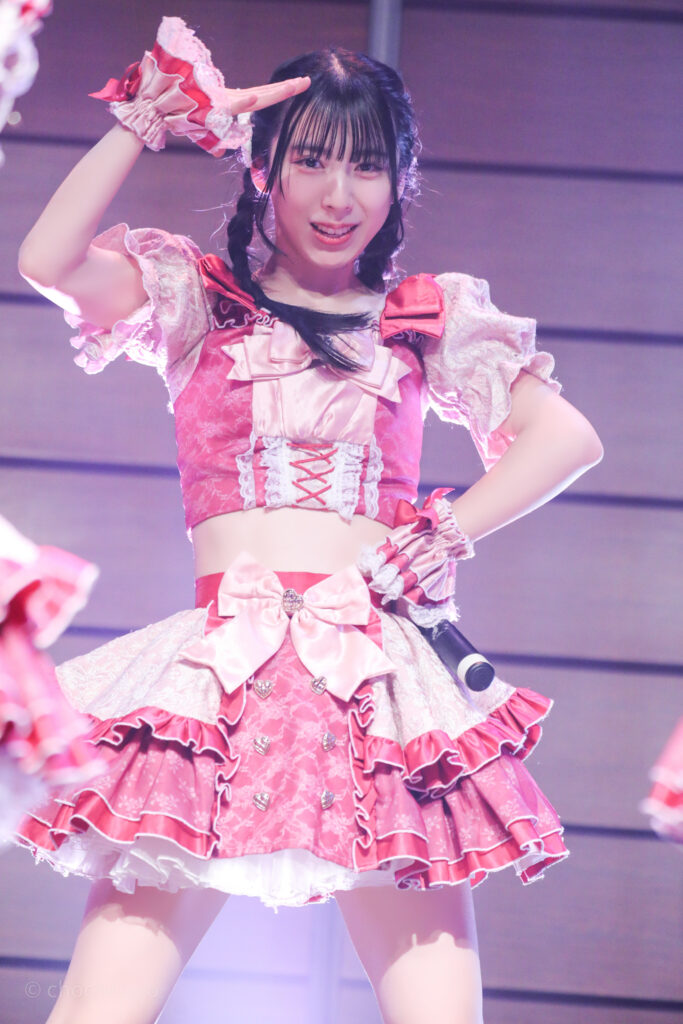 embellir(あんべりー)の水野ひなた(みずのひなた)ちゃんをライブ中に撮影した写真。
顔の前に手でひさしを作るようにしながら、こちらを見つめてくれている。
2025年12月29日時事通信ホール　ヴェルサウンドにて撮影。