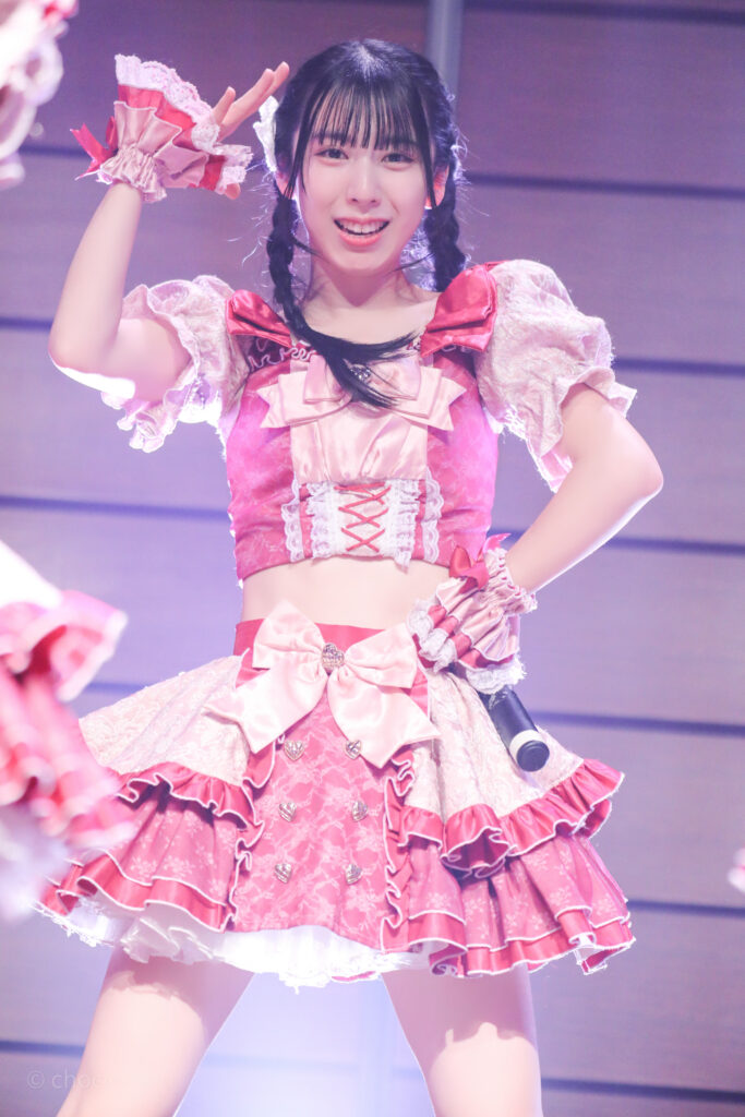 embellir(あんべりー)の水野ひなた(みずのひなた)ちゃんをライブ中に撮影した写真。
顔の前に手でひさしを作るようにしながら、こちらを見つめてくれている。
2025年12月29日時事通信ホール　ヴェルサウンドにて撮影。