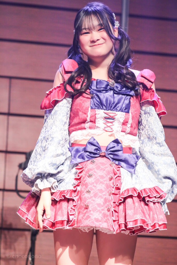 embellir(あんべりー)の恋羽あゆう(こはねあゆう)ちゃんをライブ中に撮影した写真。
こちらを見つめながら微笑んでくれている。
2025年12月29日時事通信ホール　ヴェルサウンドにて撮影。