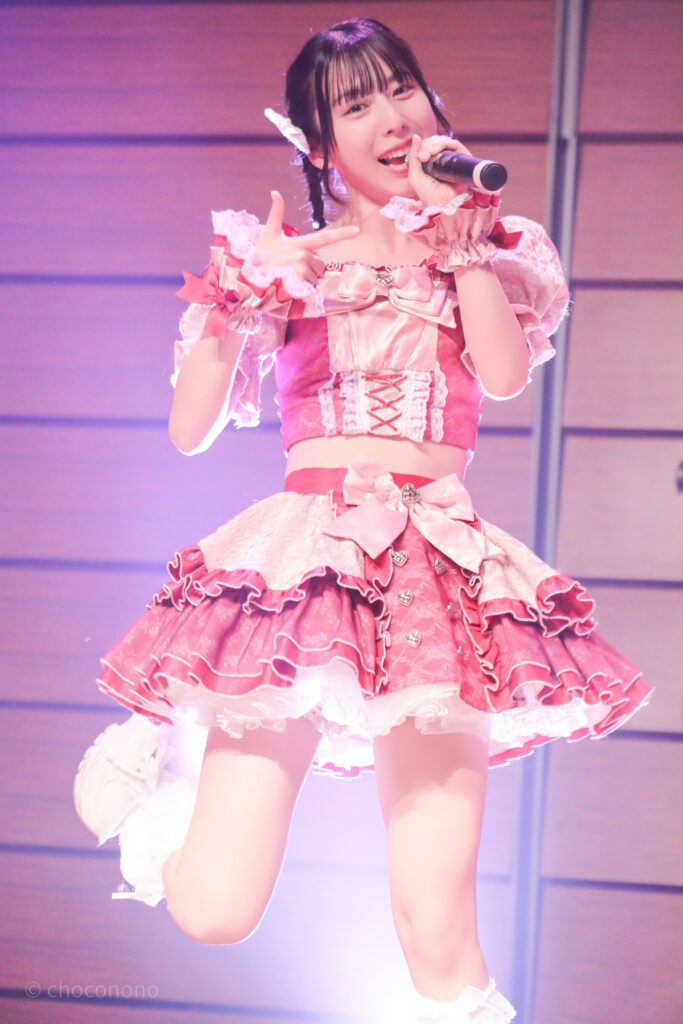 embellir(あんべりー)の水野ひなた(みずのひなた)ちゃんをライブ中に撮影した写真。
手で写真のフレームのポーズを作って「シャッターチャンス」という歌詞を表現している
2025年12月29日時事通信ホール　ヴェルサウンドにて撮影。