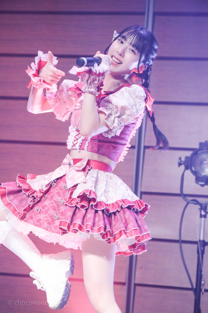 embellir(あんべりー)の水野ひなた(みずのひなた)ちゃんをライブ中に撮影した写真。
手で写真のフレームのポーズを作って「シャッターチャンス」という歌詞を表現している。腿から高く上がった脚がとても綺麗。
2025年12月29日時事通信ホール　ヴェルサウンドにて撮影。