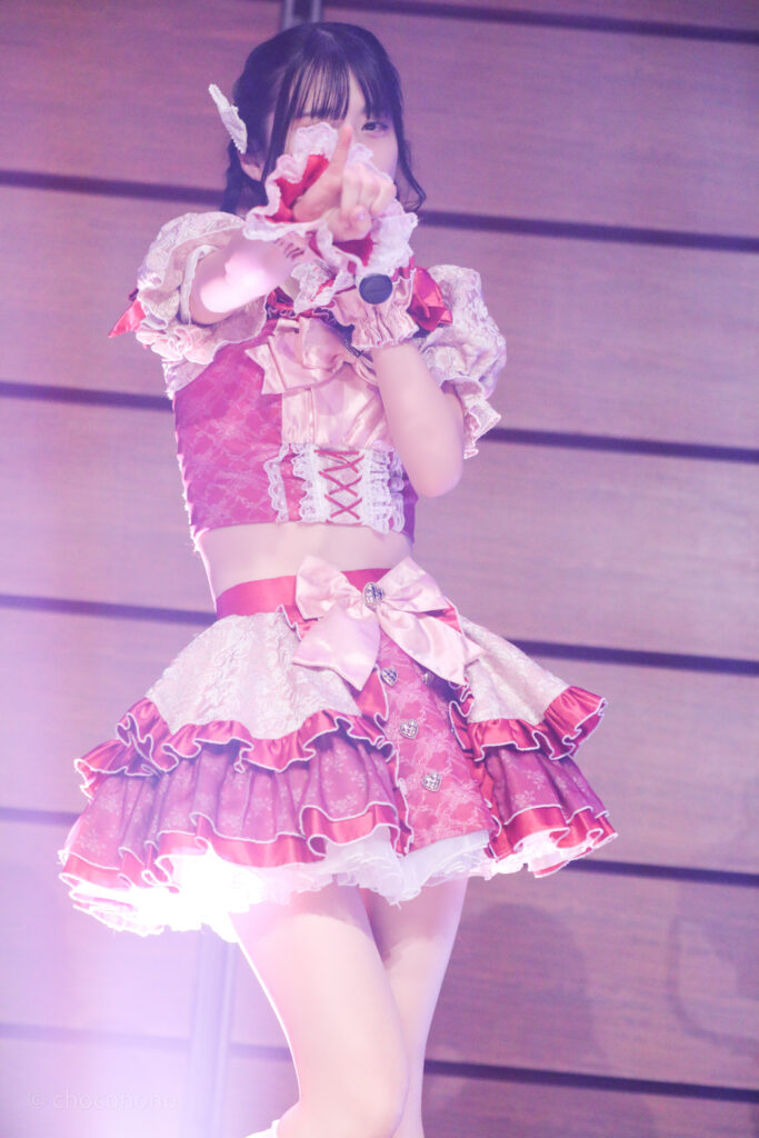 embellir(あんべりー)の水野ひなた(みずのひなた)ちゃんをライブ中に撮影した写真。
小指を立てて「約束」のポーズ。「必然的」という歌詞を表している。
2025年12月29日時事通信ホール　ヴェルサウンドにて撮影。