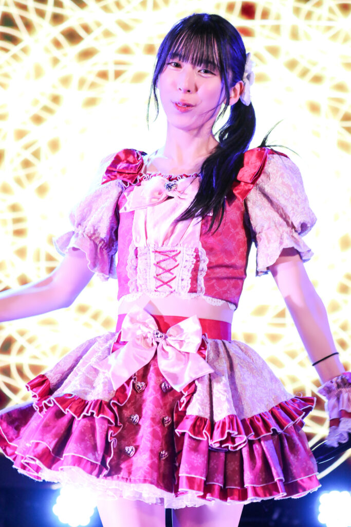 embellir(あんべりー)の水野ひなたちゃんをライブ中に撮影した写真。
背景スクリーンが明るい映像なのでそれを背負ってひなたちゃんが輝いて見える。
2025年12月6日　中野坂上S.U.B Tokyo　IDOL GARDEN PLACEにて撮影。