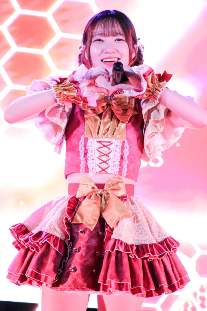 embellir(あんべりー)の泡沫あおいちゃんをライブ中に撮影した写真。
曲中のポーズでハートを作ってこちらに微笑んでくれている。
2025年　中野坂上S.U.B Tokyo　IDOL CREAM SODA!!にて撮影。