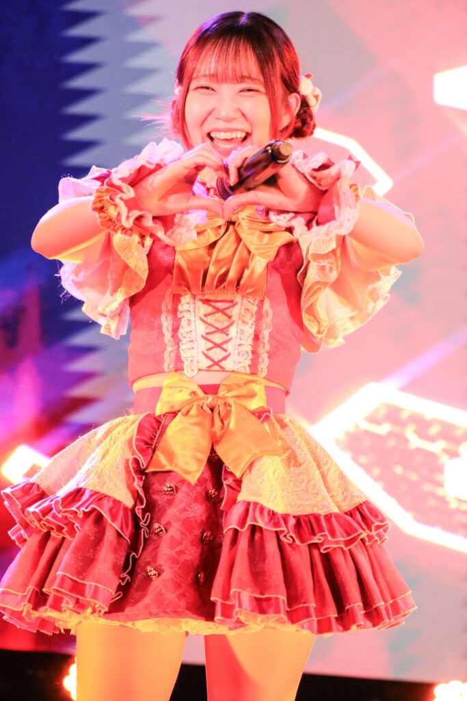 embellir(あんべりー)の泡沫あおいちゃんをライブ中に撮影した写真。
曲中のポーズでハートを作ってこちらに微笑んでくれている。
2025年　中野坂上S.U.B Tokyo　IDOL CREAM SODA!!にて撮影。