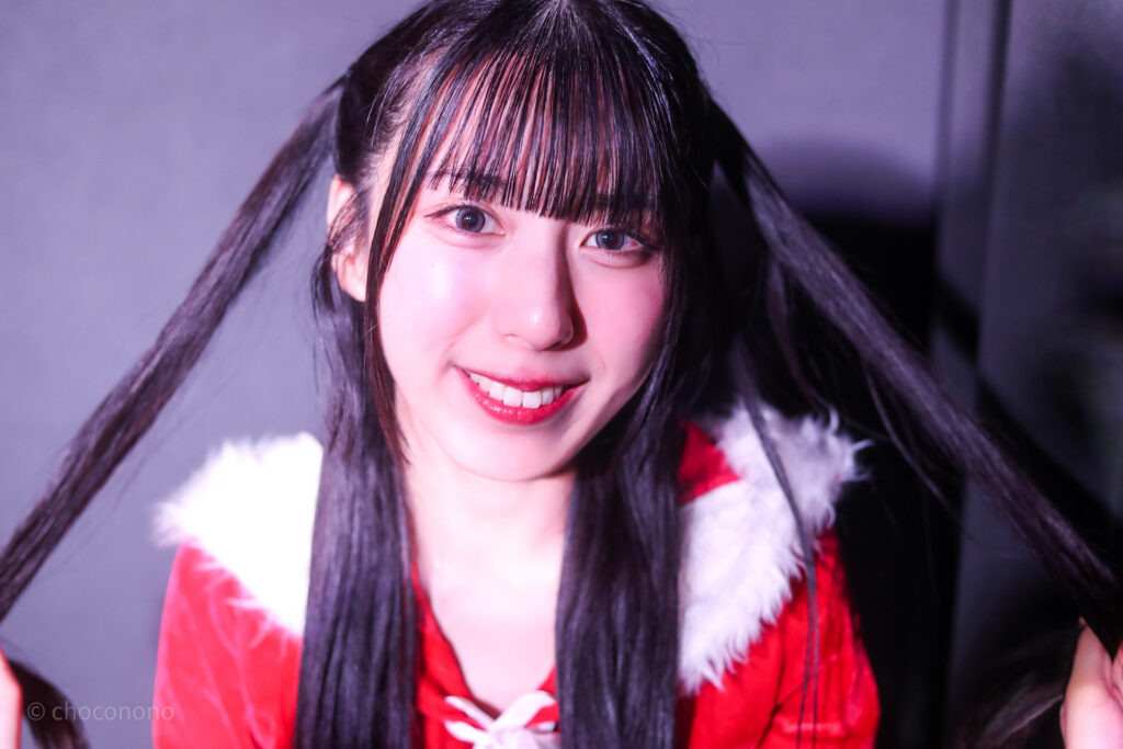 embellir(あんべりー)の水野ひなた(みずのひなた)ちゃんと特典会で撮ってもらったソロショット写真。かなり近い。ひなたちゃんは猫サンタ衣装で、ハーフツインをピンと張ってアピールしている。 2025年12月27日SHIBUYA ONE5 embellir presents Christmas Liveにて撮影。