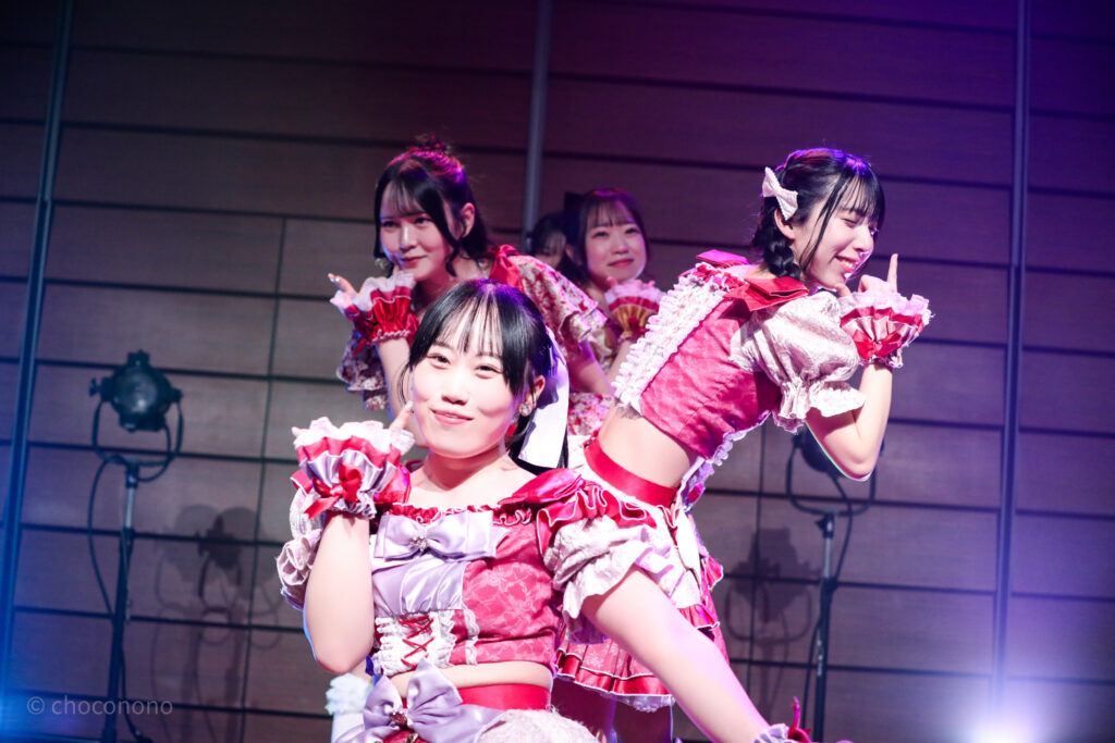 embellir(あんべりー)をライブ中に撮影した写真。
しっちゃかめっちゃかパラダイスのラストでメンバーが盾一列に並びポーズを決めている。
前から甘夏あも(あまなつあも)ちゃん、水野ひなた(みずのひなた)ちゃん、遥乃ももか(はるのももか)ちゃん、泡沫あおい(うたかたあおい)ちゃん、恋羽あゆう(こはねあゆう)ちゃん。あゆうちゃんは他のメンバーと重なってしまいほんの少ししか見えていない。
2025年12月29日時事通信ホール　ヴェルサウンドにて撮影。